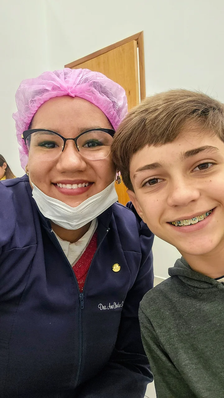 Dra. Ana e um paciente sorrindo para uma foto na clínica